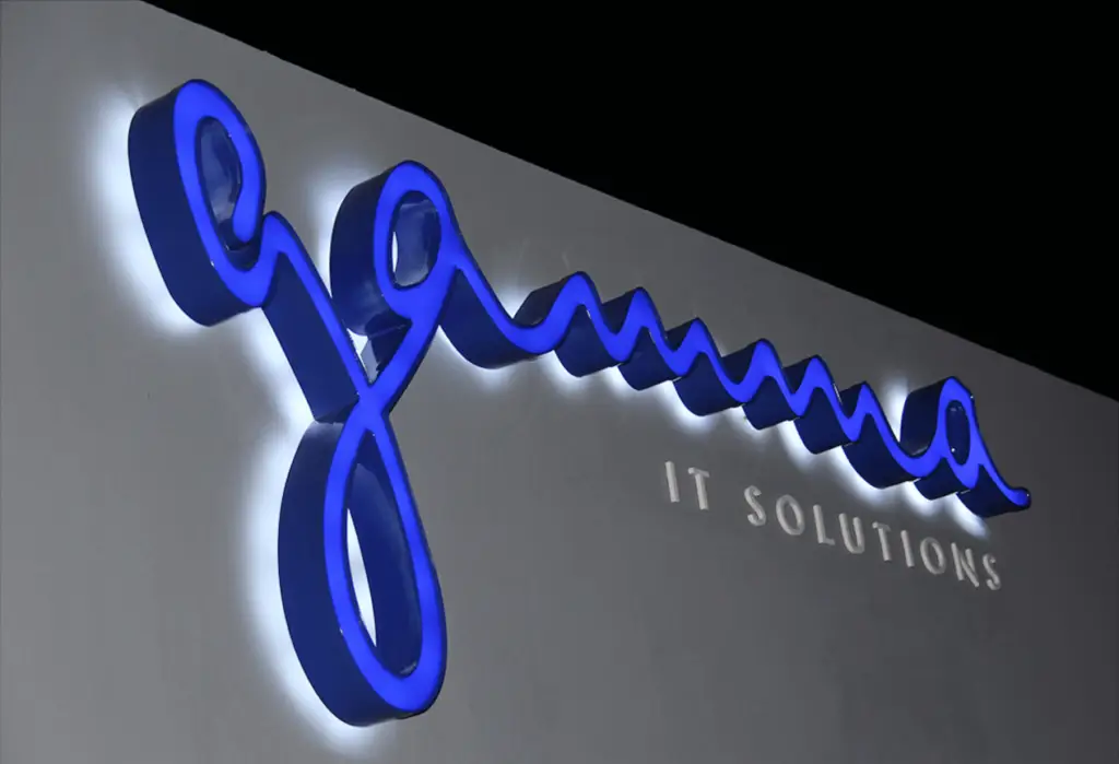 Illuminated custom sign for Gamma IT Solutions, featuring sleek channel letters with LED backlighting, crafted by Infinite Crafts in Aruba.