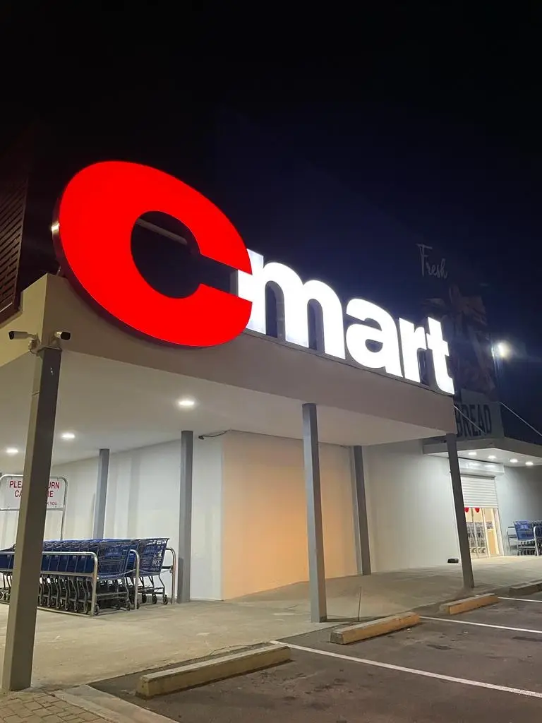 Illuminated storefront sign for Cmart, featuring bold channel letters with LED lighting, crafted by Infinite Crafts in Aruba.