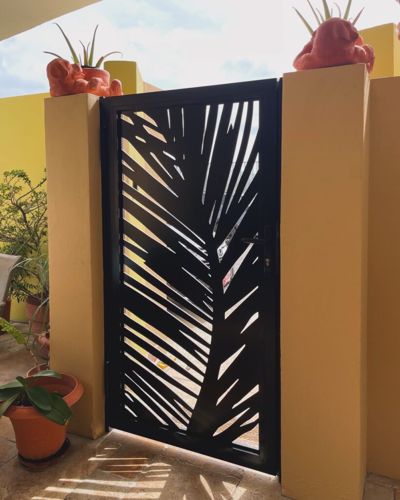 Custom metal door with palm leaf design by Infinite Crafts in Aruba, perfect for enhancing outdoor aesthetics and security.