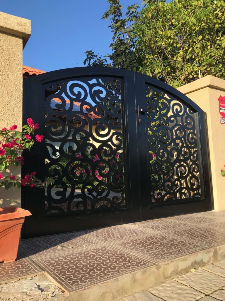 Custom aluminum gate with intricate scrollwork design, finished with automotive paint for durability in Aruba’s weather, by Infinite Crafts.